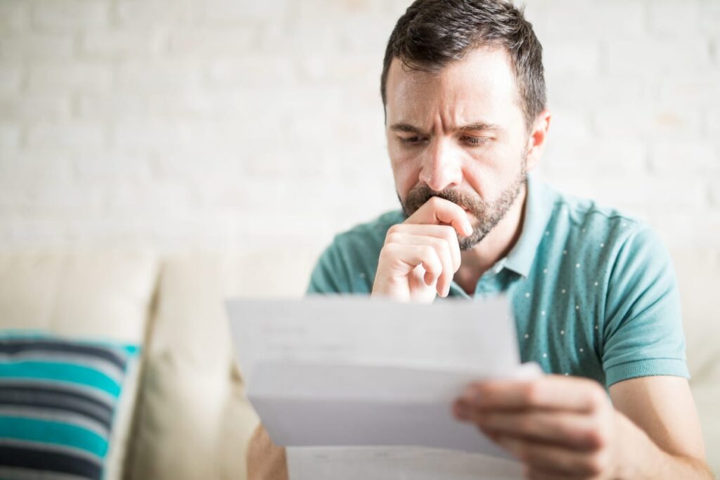 Close up shot of a young adult man reading about permit requirements