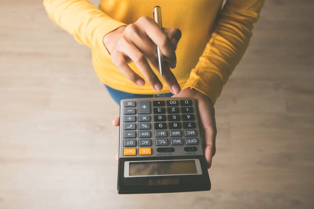 Woman using a calculator to add up the potential savings